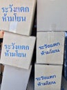 Stack of paper box, grey color and blue color of text in Thai language Ã¢â¬ÅWarning! Fragile, do not throwÃ¢â¬Â. Royalty Free Stock Photo